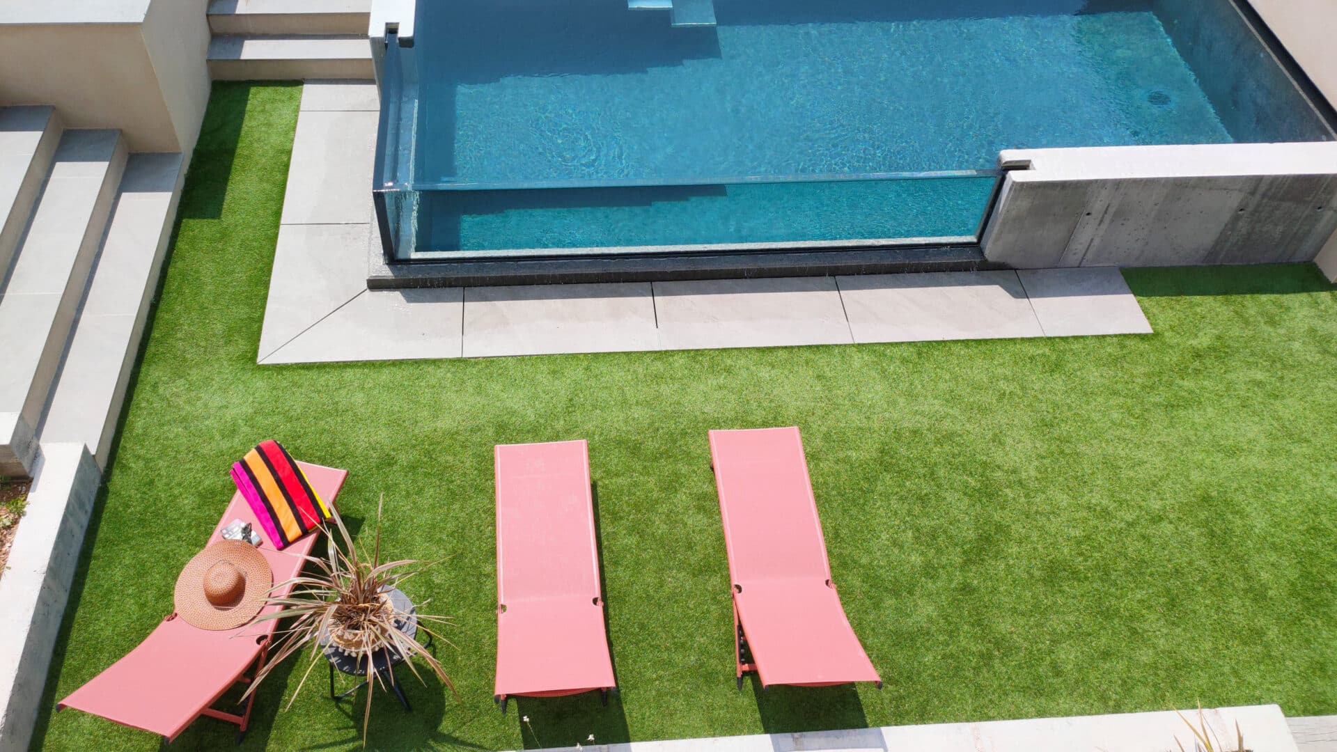 Scanzi Piscines confectionne votre piscine à débordement avec paroi vitrée.